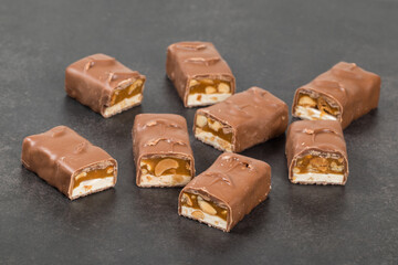 Chocolate peanut bar. With nougat and caramel. Dark background. Close up	