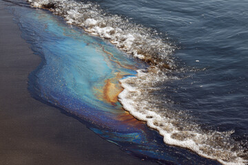 Petroleum spill mixed with other chemical substances on sea and sand surface