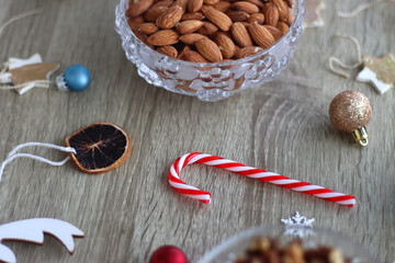 Various Christmas decorations, cookies, chocolate and nuts on wooden background. Selective focus.
