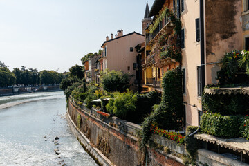 Verona cityscape with buildings along the Adige River on a sunny day.