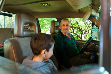 Elder and child sharing a moment in a car