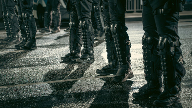 Nighttime view of a police officer's feet and legs in full combat gear