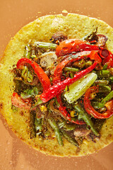 Vegetable Fajitas in tortilla with mushrooms, peas, bell peppers, cheese, corn, salad and sauces