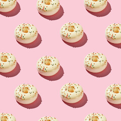 Overhead view of various donuts with confetti arranged on colored background