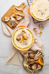 Quiche with chanterelle mushrooms, oyster mushrooms, button mushrooms, and cheese in two serving dishes