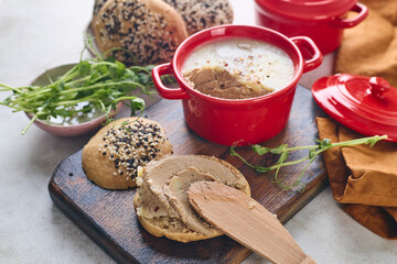 Gourmet Liver Pate Appetizer with Sesame Seed Bagels and and Fresh Pea Shoots on Rustic Wooden Board