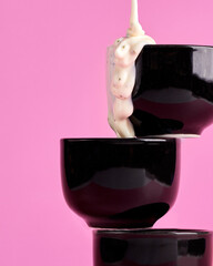 Thick white mayonnaise, ranch or garlic sauce is poured from bottle into gravy boat