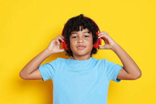 Portrait of little boy with headphones on yellow background - Powered by Adobe