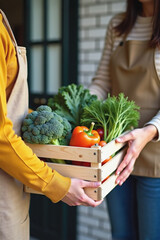 Woman delivering fresh organic vegetables in wooden crate to customer at home entrance. Local farm produce delivery service with broccoli, lettuce, pepper and tomatoes for healthy eating lifestyle.