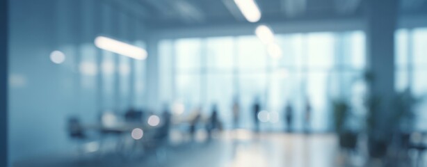 The blurred office interior with silhouetted businesspeople by bright floor-to-ceiling windows