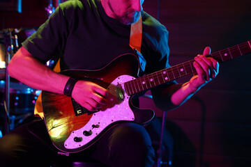 Obraz premium Man playing electric guitar on stage, closeup