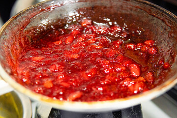 Cooking sweet strawberry jam in a pan