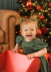 bebe feliz celebra o natal em decora&ccedil;&atilde;o linda com arvore e luzes 