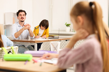 Teacher explaining exercise to students in classroom