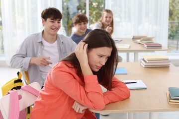 Obraz premium Students bullying their classmate in classroom, selective focus