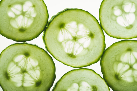 Close-up of fresh cucumber slices on white background