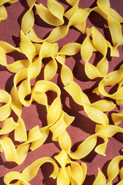 Close-up of dry pasta on a textured brown background