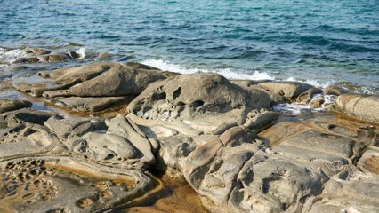 Fototapeta premium A rocky, bizarre shoreline and coastal slope of a wild sea beach near the resort of Cifalù, Sicily.