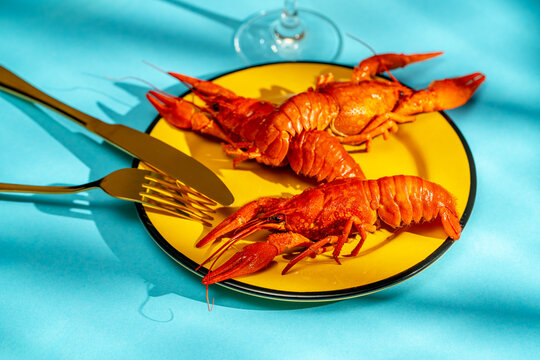 Crayfish Plated with Utensils on Vibrant Blue Background