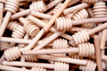 Wooden honey dippers piled in abundance for culinary use