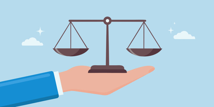 Hand holding scales of justice against a light blue sky background