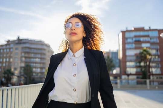 Confident businesswoman with curly hair in an urban setting