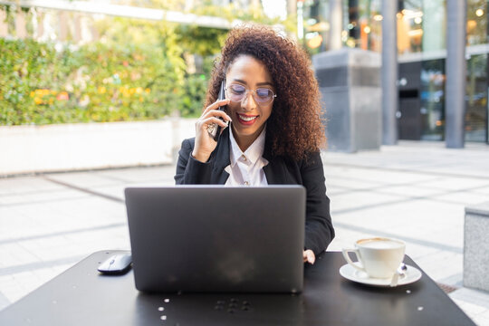 Businesswoman with curly hair working outdoors