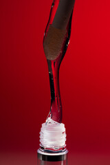 Lip oil applicator with clear glossy formula and bubbles on red background, collection of macro shots for cosmetic branding, skincare hydration and beauty product advertising banners
