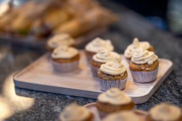 Sweet chocolate muffins with whipped cream on the table on a white plate. Luxurious baked cakes at a celebration.