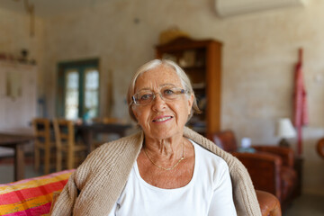 Senior woman smiling wearing glasses at home