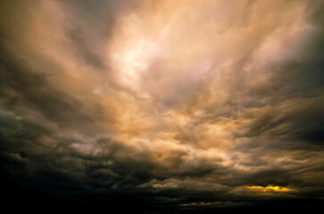 The ominous clouds create a moody atmosphere, with the sun breaking through the darkness