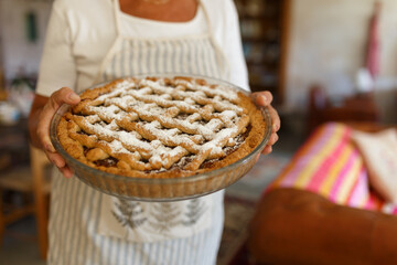 Woman presenting homemade fruit pie dessert