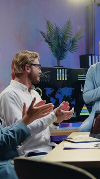 Handsome satisfied motivated african american worker thanking when another members of joint working team clapping hands greeting him for effective report in evening office