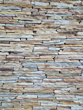 Rustic stacked stone wall texture background with natural beige and grey colors