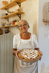 Senior woman holding homemade apple fruit pie