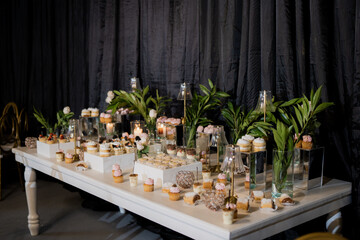 Elegant wedding dessert table with sweet pastries and cupcakes