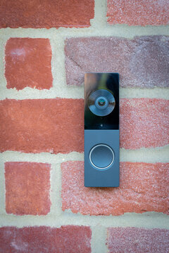 Modern doorbell on red brick house in London
