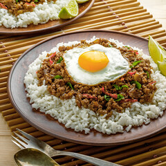 Classic Thai Rice Dish with Minced Meat, Fried Egg, and Lime