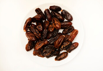 Juicy dates on a plate. Dried fruits. Sweet dried fruits.