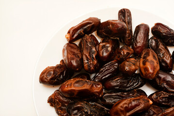 Juicy dates on a plate. Dried fruits. Sweet dried fruits.