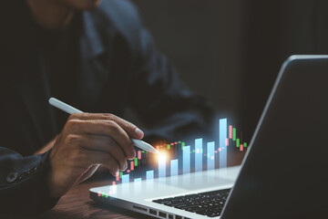 A businessman analyzing digital bar charts on a laptop, representing business analytics, financial growth, data insights, and performance monitoring in modern workplaces.