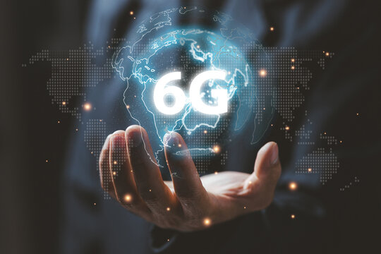 A businessman holding a glowing digital globe with a 6G symbol, representing future connectivity, ultra-fast networks, advanced communication, and next-generation wireless technology.