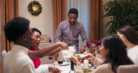 At a birthday party, a young student of multi-ethnic background stands at the table in a shirt,...