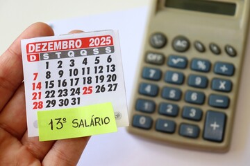 Person holding calendar with "13º Salário" text. 13º salário Brasileiro concept. Brazilian CLT.