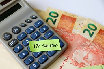 13º salário Brasileiro concept. "13º Salário" text, BRL Real banknotes, and calculator. 
