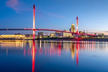 Omaha, Nebraska, USA downtown city skyline and pedestrian bridge at night. 1942