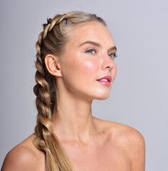 Beautiful face of young adult woman with clean fresh skin.  Has a braided hairstyle