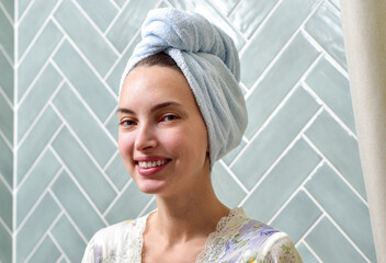 Beautiful Young Woman applying facial moisturizing cream in bathroom.Home interior. Skincare concept