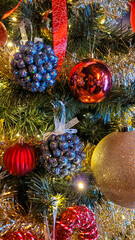 A view of a red, blue and yellow Christmas tree decorated with various Christmas toys and decor elements.