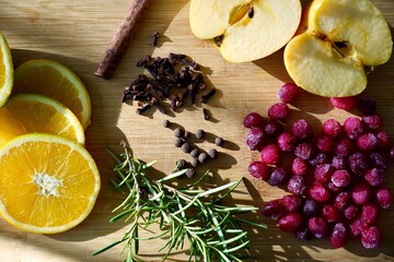 Top View of Oranges, Apples, Cranberries, Rosemary, and Spices on Cutting Board — Natural Potpourri Ingredients